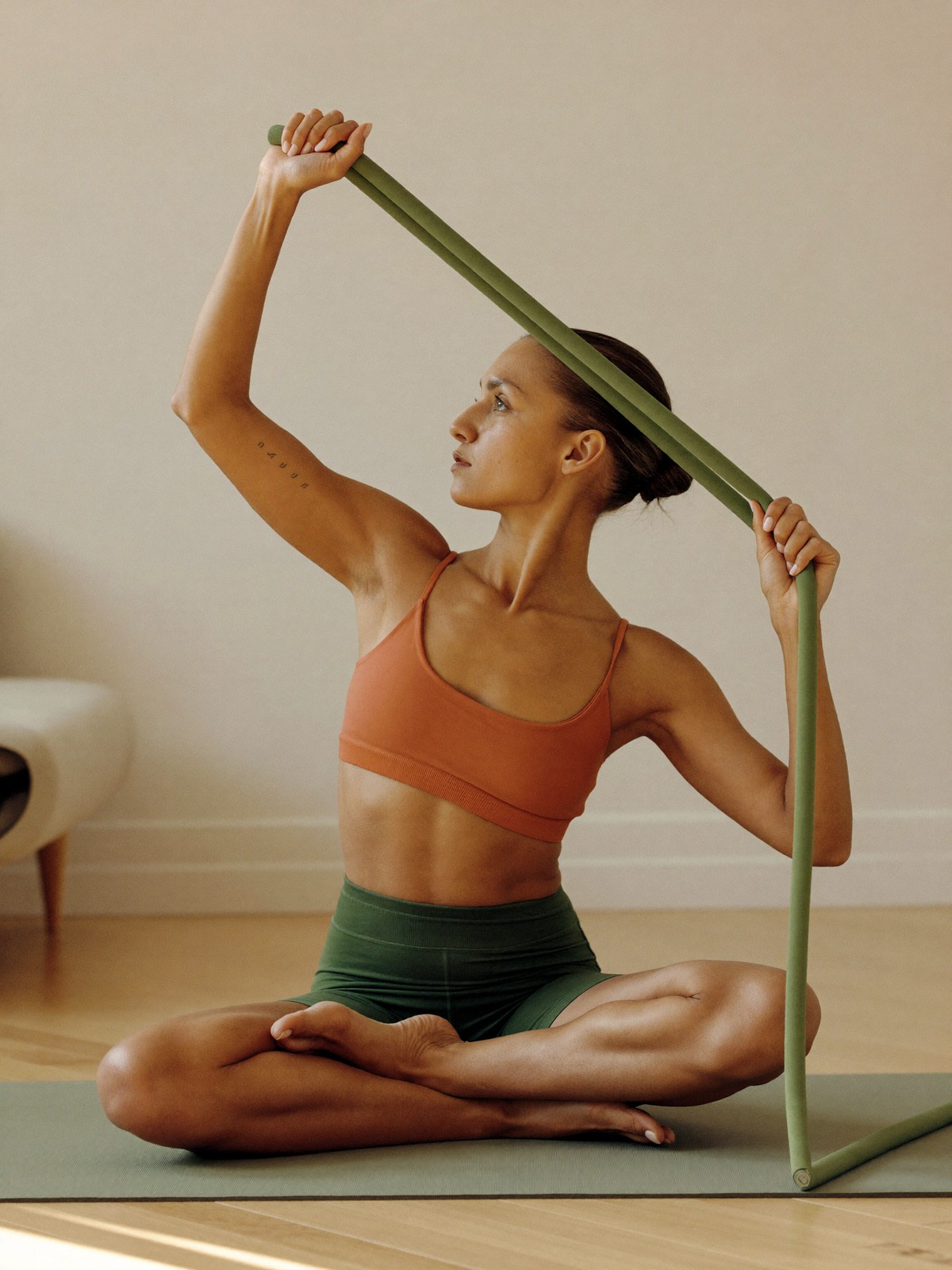 Resistance bands, a rolled yoga mat, and light dumbbells resting in a bright corner of a home
